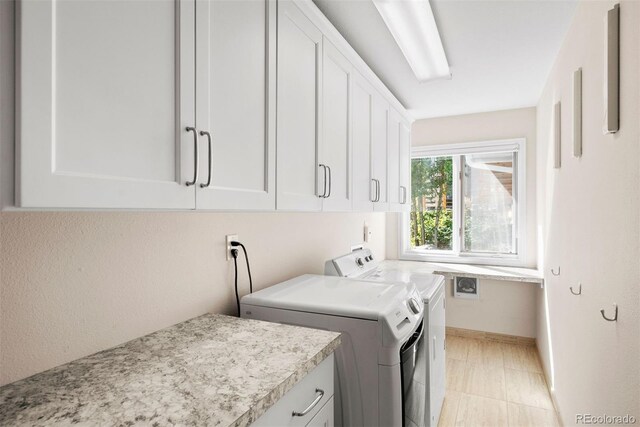 clothes washing area featuring cabinets and independent washer and dryer