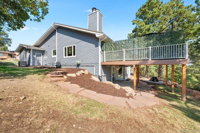 back of property with a wooden deck and a patio area