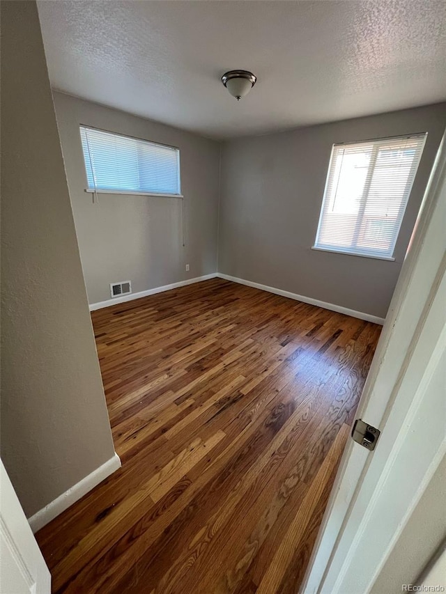 1245 Yates St, Denver, CO 80204 - empty room with wood finished floors and a textured ceiling