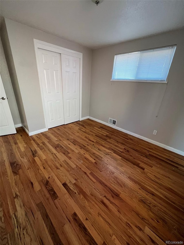 1245 Yates St, Denver, CO 80204 - unfurnished bedroom with wood finished floors and a closet