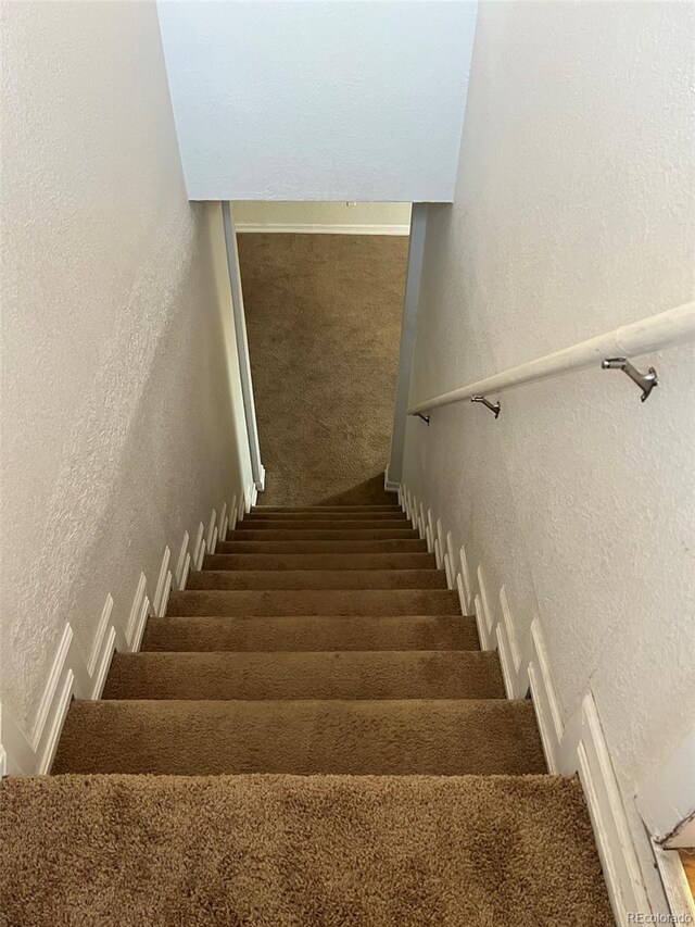 1245 Yates St, Denver, CO 80204 - staircase featuring a textured wall and carpet flooring