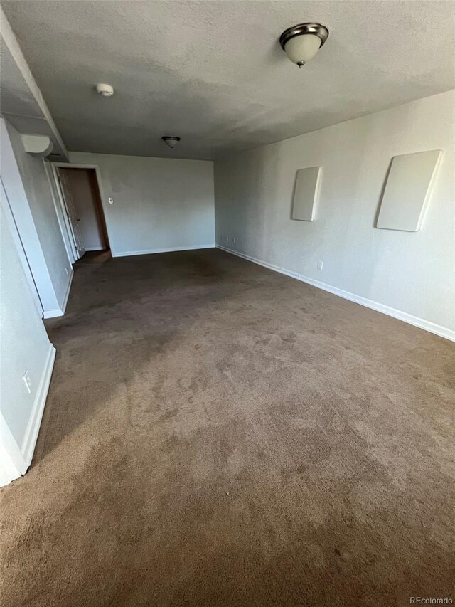 1245 Yates St, Denver, CO 80204 - unfurnished room featuring dark carpet, a textured ceiling, and a smoke detector