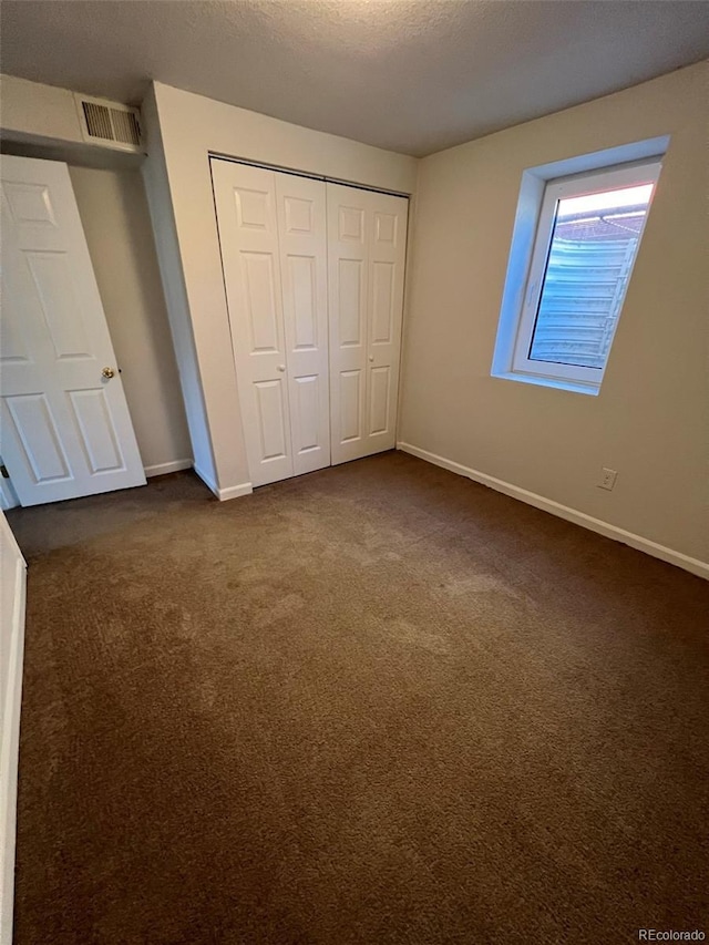 1245 Yates St, Denver, CO 80204 - unfurnished bedroom with a closet and dark colored carpet