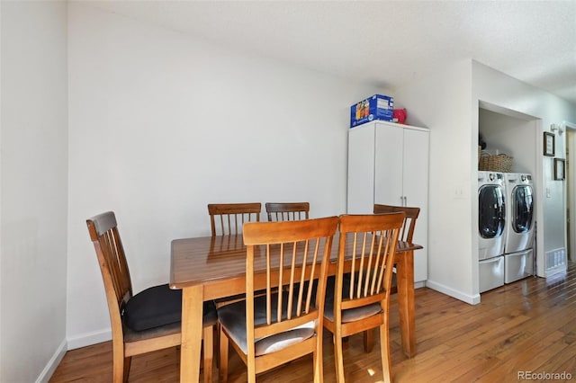 dining room featuring washing machine and clothes dryer and hardwood / wood-style floors