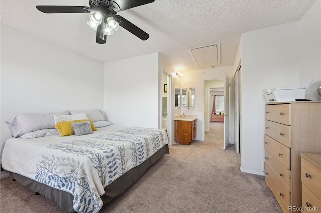 carpeted bedroom with ceiling fan, a textured ceiling, and ensuite bath