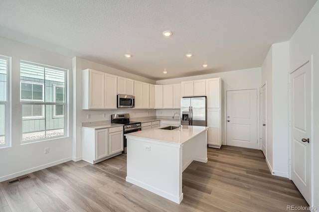 708 N Bently St, Watkins, CO 80137 - kitchen featuring appliances with stainless steel finishes, a sink, light wood-style flooring, light countertops, and white cabinets