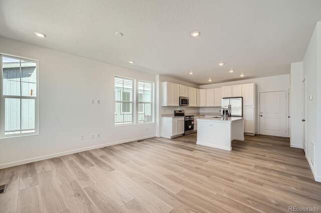 708 N Bently St, Watkins, CO 80137 - kitchen with appliances with stainless steel finishes, healthy amount of natural light, light countertops, light wood-style floors, and recessed lighting