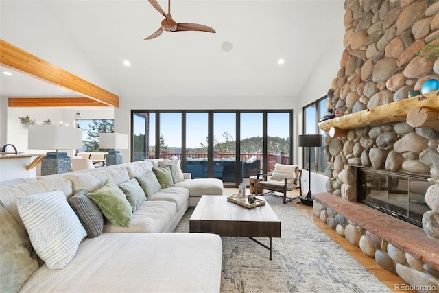 living area with light wood-style flooring, a fireplace, beamed ceiling, and recessed lighting