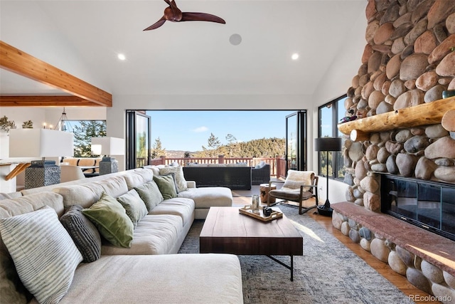 living room with a fireplace, high vaulted ceiling, a wealth of natural light, and wood finished floors