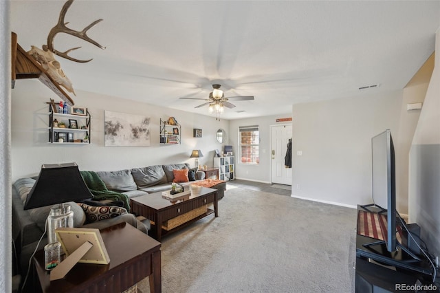 carpeted living area featuring baseboards, visible vents, and ceiling fan