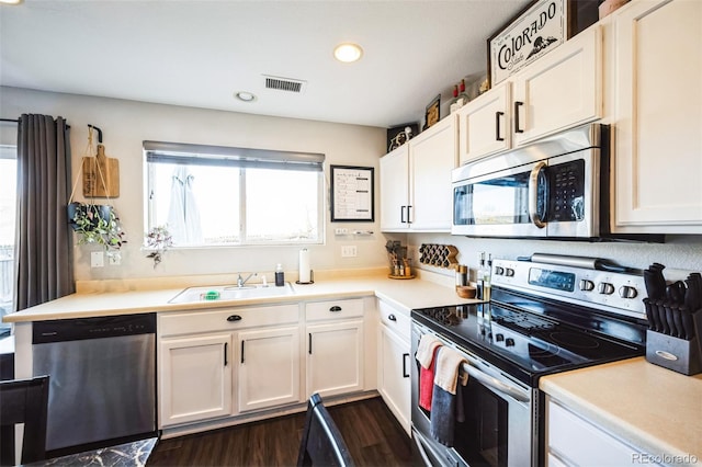 kitchen featuring visible vents, a sink, white cabinetry, stainless steel appliances, and light countertops