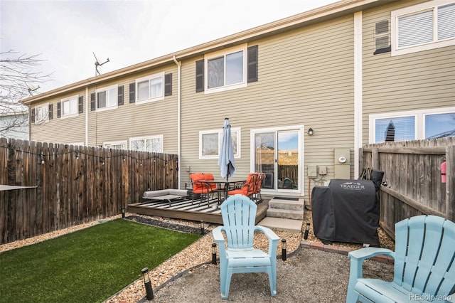 back of house featuring a deck, a yard, and a fenced backyard