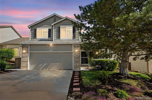 4857 Tarcoola Ln, Highlands Ranch, CO 80130 - view of front of house with a garage, concrete driveway, and brick siding