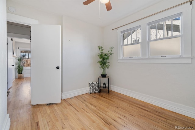 unfurnished room with ceiling fan, plenty of natural light, and light wood-type flooring