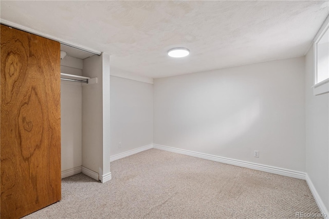 unfurnished bedroom featuring light carpet and a closet