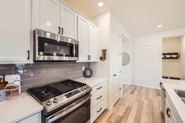 515 176th Ave, Broomfield, CO 80023 - kitchen featuring appliances with stainless steel finishes, light wood finished floors, tasteful backsplash, white cabinets, and light countertops