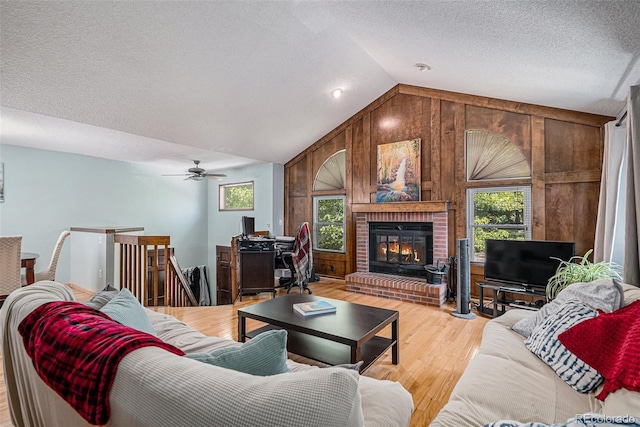 16724 E Hialeah Ave, Centennial, CO 80015 - living room featuring plenty of natural light, vaulted ceiling, wooden walls, light wood finished floors, and a textured ceiling