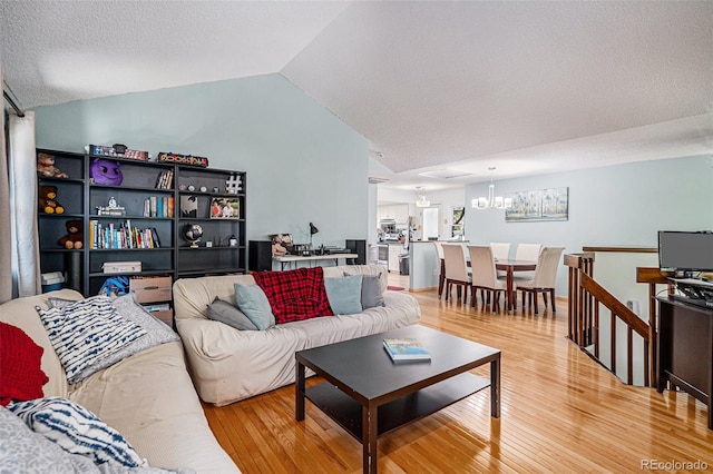 16724 E Hialeah Ave, Centennial, CO 80015 - living room with wood finished floors, a textured ceiling, lofted ceiling, and a chandelier