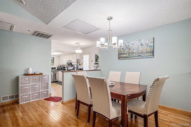 16724 E Hialeah Ave, Centennial, CO 80015 - dining room featuring light wood-style floors, a textured ceiling, and a chandelier