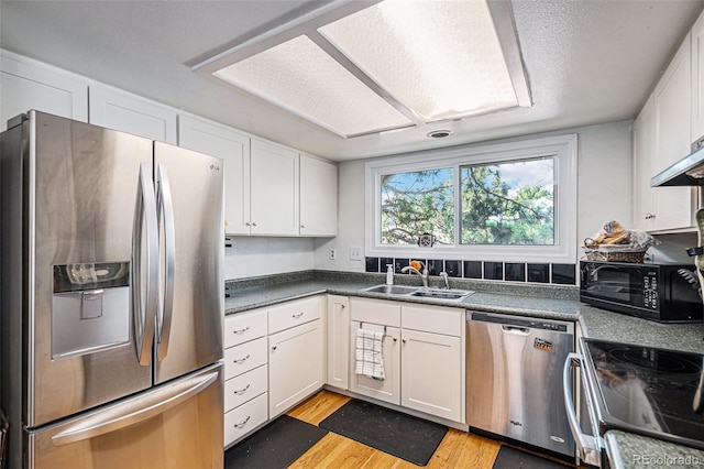 16724 E Hialeah Ave, Centennial, CO 80015 - kitchen with appliances with stainless steel finishes, white cabinets, light wood-type flooring, and dark countertops