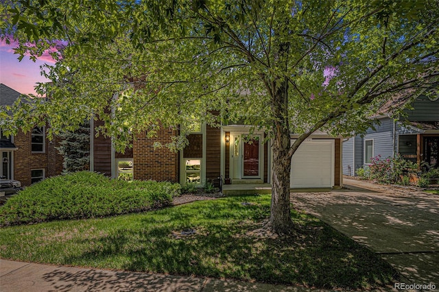 16724 E Hialeah Ave, Centennial, CO 80015 - view of property hidden behind natural elements featuring concrete driveway, an attached garage, and brick siding