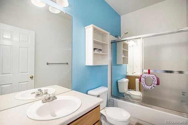 bathroom with shower / bath combination with glass door, vanity, and toilet