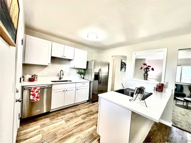 8820 Cody St, Broomfield, CO 80021 - kitchen with stainless steel appliances, a sink, light wood-type flooring, and white cabinetry