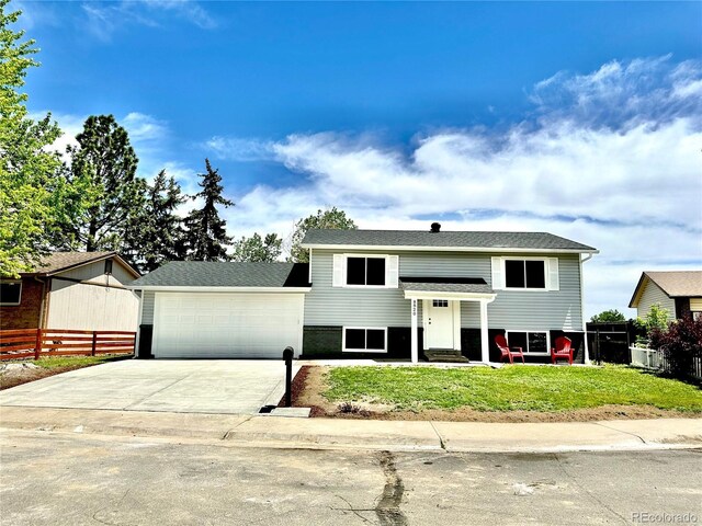 8820 Cody St, Broomfield, CO 80021 - raised ranch featuring entry steps, concrete driveway, and an attached garage