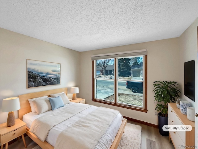 bedroom with wood-type flooring and a textured ceiling