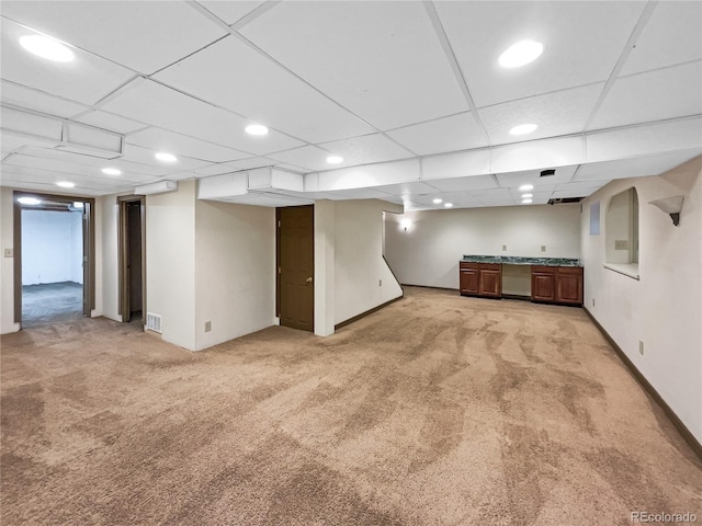 basement with light carpet and a drop ceiling