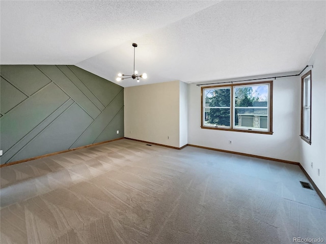 interior space with light carpet, a textured ceiling, vaulted ceiling, and a notable chandelier