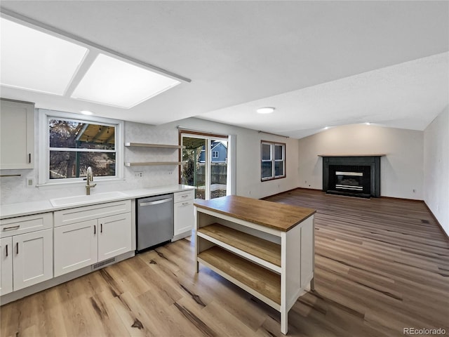 kitchen with white cabinets, dishwasher, backsplash, and sink