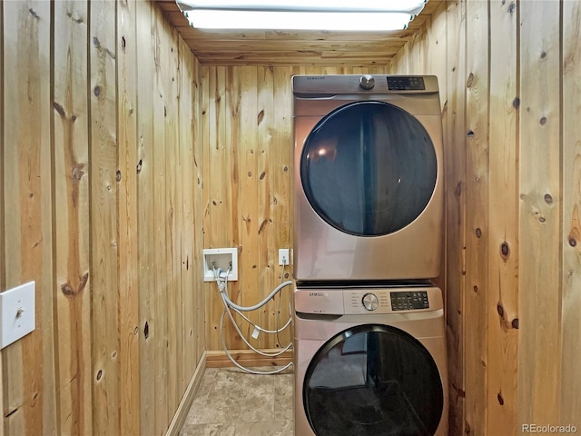 laundry area featuring wooden ceiling, stacked washer and dryer, and wooden walls