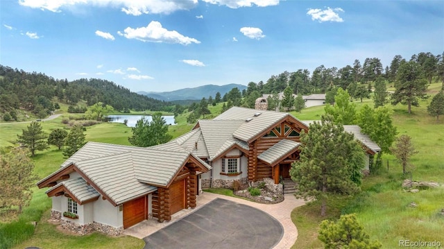 28267 Meadowlark Dr, Golden, CO 80401 - view of front of property featuring a water and mountain view, a chimney, log siding, asphalt driveway, and a garage
