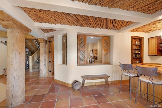 28267 Meadowlark Dr, Golden, CO 80401 - dining space with stairway, tile patterned floors, beamed ceiling, and bar area