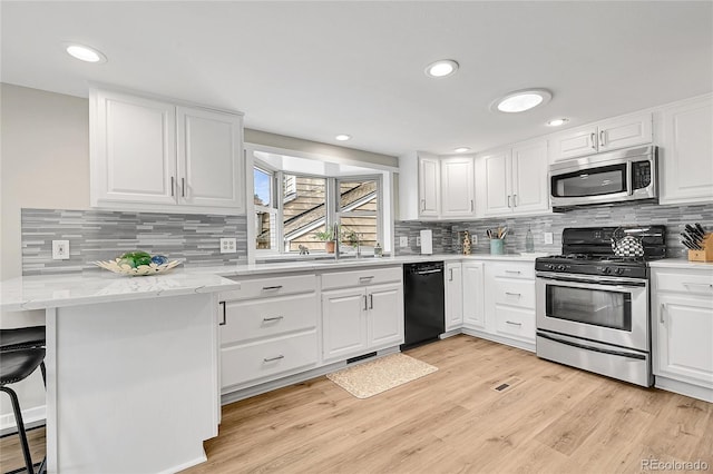 5050 W 102nd Ave, Westminster, CO 80031 - kitchen featuring appliances with stainless steel finishes, a sink, white cabinets, decorative backsplash, and recessed lighting