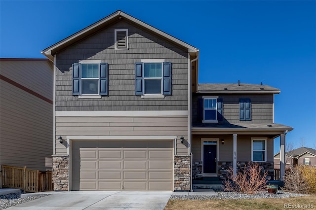 view of front of house with a garage, driveway, stone siding, and fence