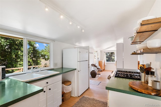 426 Corona Ave, Palmer Lake, CO 80133 - kitchen with freestanding refrigerator, light wood-style flooring, track lighting, white cabinetry, and dark countertops