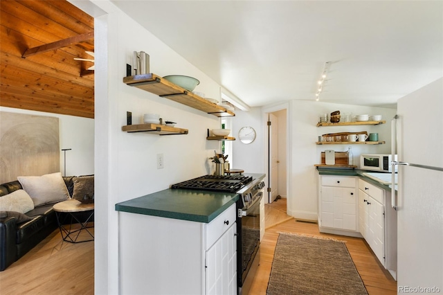 426 Corona Ave, Palmer Lake, CO 80133 - kitchen with open shelves, white appliances, dark countertops, light wood finished floors, and lofted ceiling
