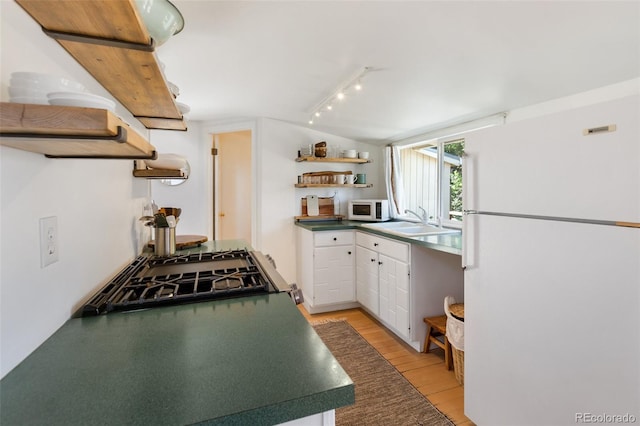426 Corona Ave, Palmer Lake, CO 80133 - kitchen with open shelves, white appliances, dark countertops, white cabinets, and light wood-style flooring