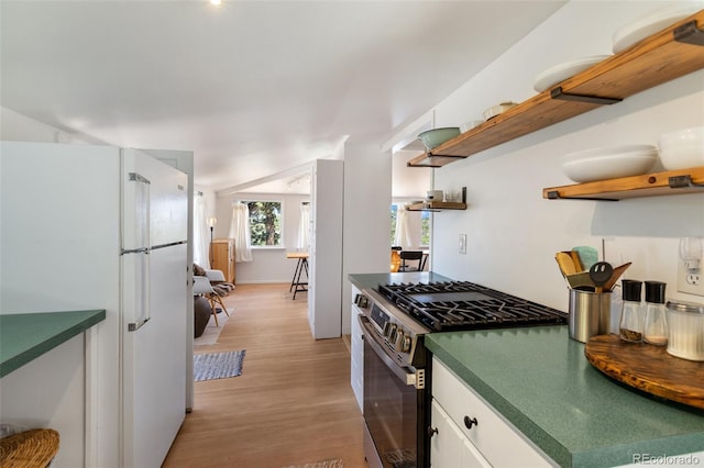426 Corona Ave, Palmer Lake, CO 80133 - kitchen featuring open shelves, freestanding refrigerator, stainless steel gas range oven, dark countertops, and light wood finished floors