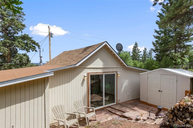 426 Corona Ave, Palmer Lake, CO 80133 - rear view of house featuring a shingled roof and a storage shed