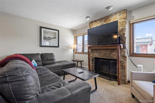 carpeted living room with a stone fireplace and a baseboard heating unit