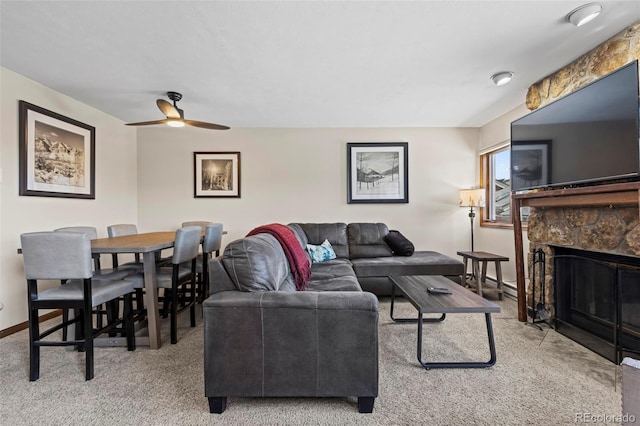 living room featuring baseboards, carpet flooring, a fireplace, and ceiling fan