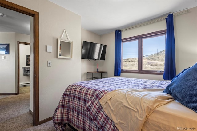 bedroom featuring a baseboard heating unit, carpet flooring, and baseboards