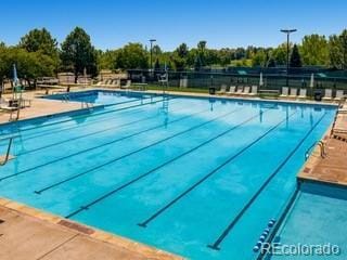 pool with a patio and fence