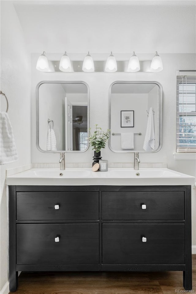 full bath featuring a sink, wood finished floors, and double vanity