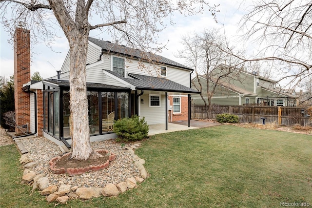 back of house with a patio area, a lawn, fence, and a sunroom