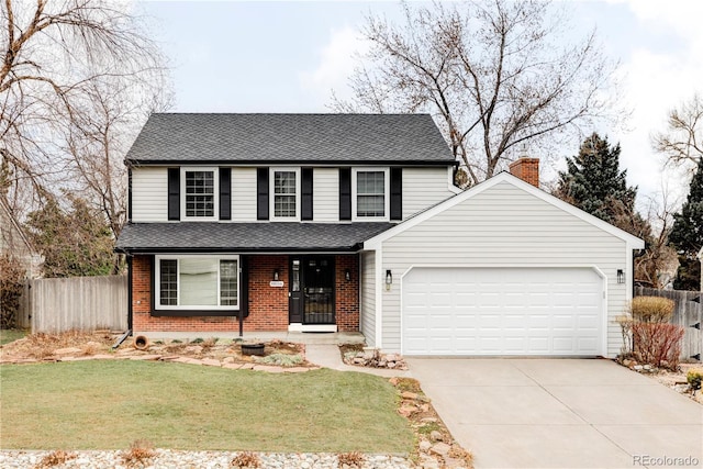 traditional-style house with a front yard, fence, driveway, a garage, and brick siding