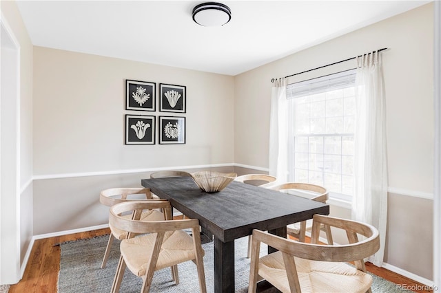 dining room featuring wood finished floors and baseboards